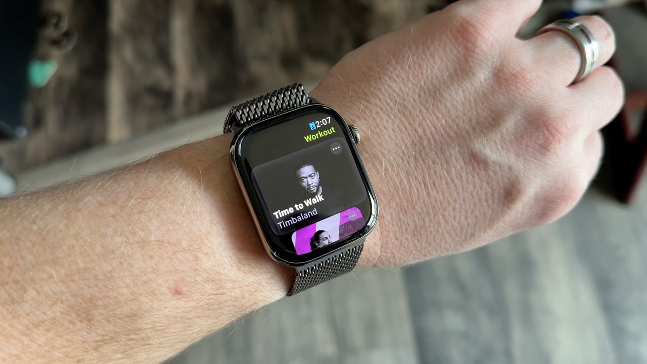 Close-up of a smart watch on a wrist displaying a 'Time to Walk' workout with an image of a man.